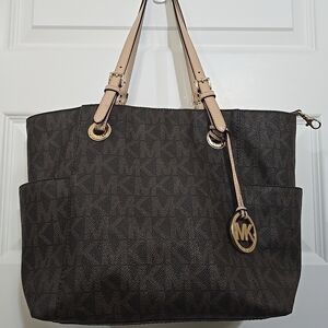 Michael Kors Jet Set Signature Logo Tote Handbag in brown.